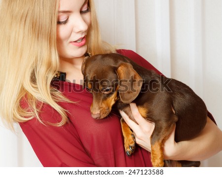 Pets and people, pet adoption. Elegant woman posing with her mixed dog pet indoor, hugging lovingly embraces her puppy.