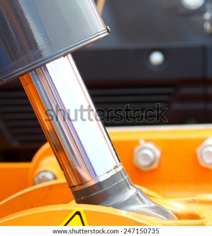 close up of machine track piston hydraulic system of a digger yellow industrial detail