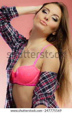 closeup young woman long hair wearing purple plaid shirt pink lingerie, female breasts in bra on red
