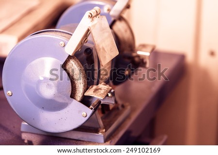 Violet bench grinder, electric tool in workshop,