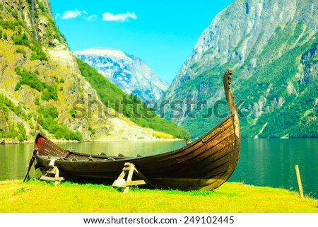 Tourism and travel. Mountains and fjord Sognefjord in Norway, Scandinavia. Old viking boat on seashore.