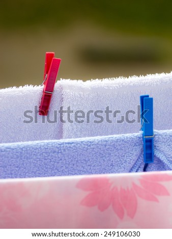 Housework. Clean wet laundry towels with clothespins hanging to dry on the line clothesline outdoor. Rural scene.