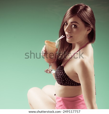 People beauty spa and relaxation concept - lovely young woman wearing swimsuit with cocktail glass in water at poolside