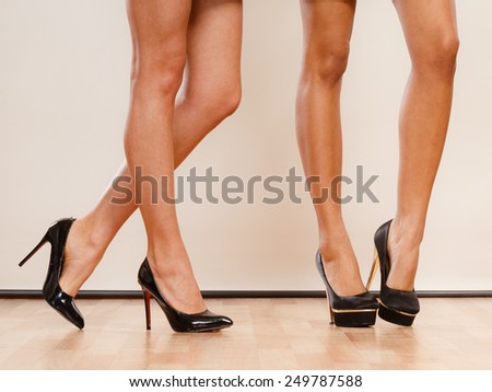 Female fashion. Closeup black high heels spiked fashionable shoes on sexy female legs.