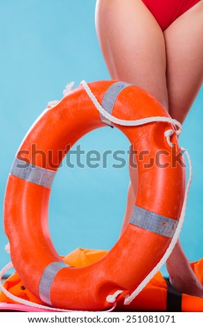 Accident prevention and water rescue. Life buoy ring lifebelt and female legs studio shot blue background