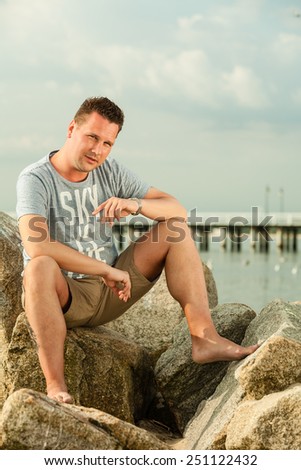 Happiness summer vacation and people concept. Fashion portrait handsome man full length on the stone beach landscape