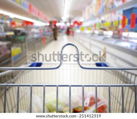 view of a shopping cart with grocery items at supermarket  blurred background
