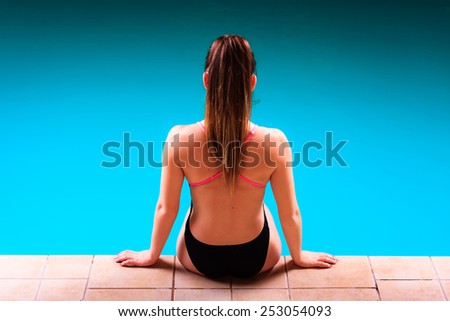 Sport active lifestyle. Sporty woman female swimmer muscular fit body  in swimsuit relaxing at poolside indoor swimming pool.