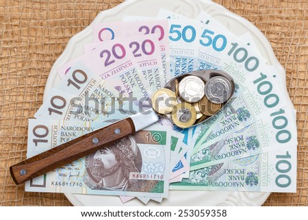 Cost of living, price of eating food budget concept. Polish money on kitchen table, plate with banknotes cutlery