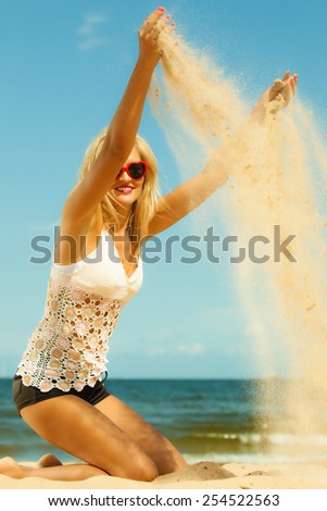 vacation happiness and freedom concept. Beautiful girl playing with sand on beach. Young woman having fun relaxing on the sea coast.