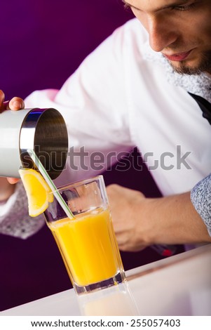 Young stylish man bartender preparing serving alcohol cocktail drink  over bar counter
