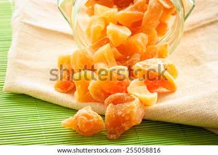 Closeup candied crystallized ginger candy pieces in glass on table. Healthy eating, home remedy for nausea inflammation, colds.