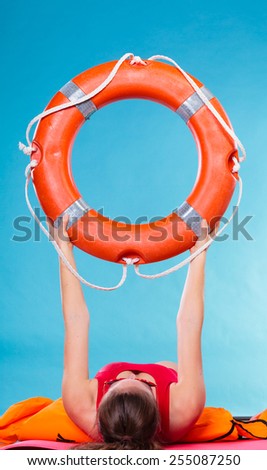Accident prevention and water rescue. Woman holding life buoy ring lifebelt studio shot blue background