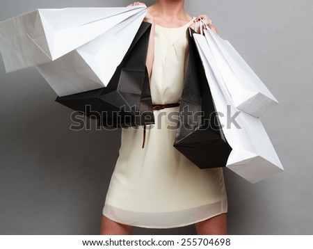 Woman holding black white paper shopping bags. Elegant lady bright dress buying clothes. Sale and retail.