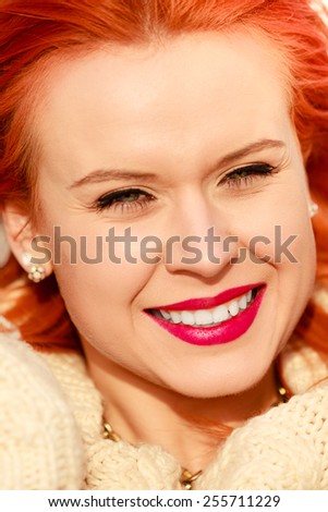Winter fashion. Beauty face portrait red hair young woman in warm clothing outdoor enjoying sunlight on sunny day.