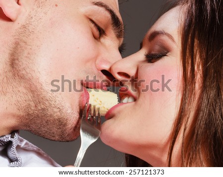 People love dating and happiness concept. Attractive couple eating banana together, man and woman sharing fruit face to face.