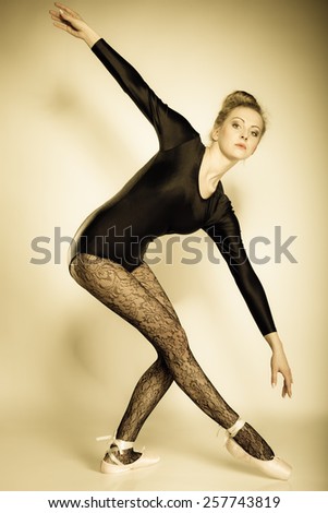 Graceful beautiful woman ballet dancer full length studio shot sepia vintage aged tone