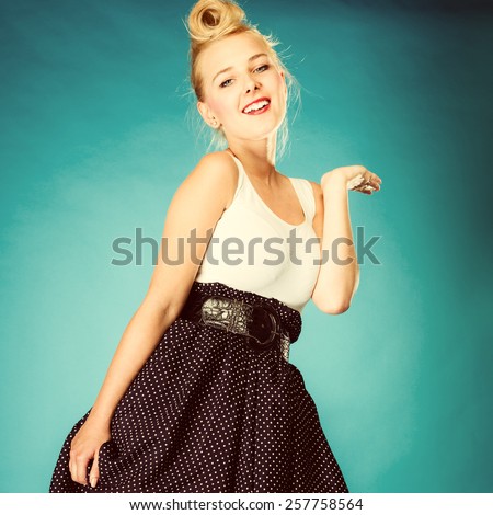 Retro style and dance pose. Blonde pin up girl dancer in studio. Vintage photography.
