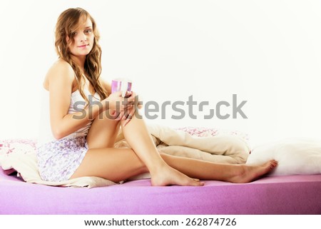 Relax, home, happiness and people concept. Young woman sleepy girl sitting relaxing on bed at morning with cup of tea coffee