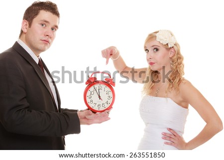 Wedding concept. Time to get married. Unhappy undecided bride and groom with red alarm clock making decision or to be late isolated on white