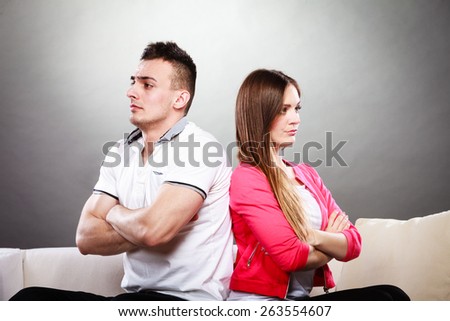 Bad relationship concept. Man and woman in disagreement. Young couple after quarrel sitting on sofa back to back