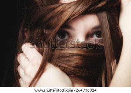 Loneliness stress anxiety and women concept. Closeup portrait beautiful woman dark haired, teen girl covering face by long brown hairs on black