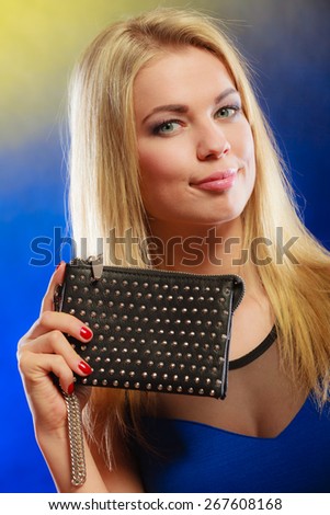Fashion elegant evening outfit. Close up lovely woman face blonde long hair girl showing black rivet leather handbag clutch in hand