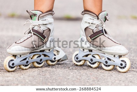 Enjoying roller skating rollerblading on inline skates sport in park. Outdoor activities. Part of human legs in sport shoes.