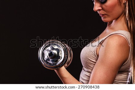 Bodybuilding. Strong fit woman exercising with dumbbells. Closeup muscular girl lifting weights on black