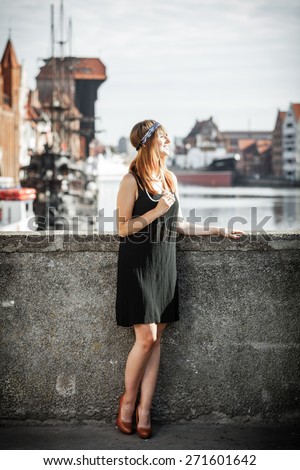 Flapper girl in full length. Retro style fashion vintage woman from roaring 1920s outdoor on the street. Old town Gdansk Danzig in the background