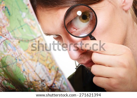 Travel vacation concept. man looking through a magnifying glass loupe at map