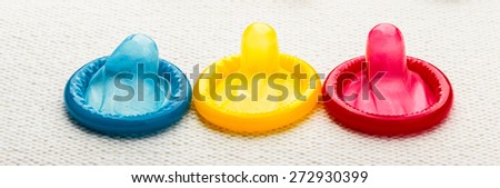 Healthcare medicine, contraception and birth control. Closeup colorful condoms on white cloth.