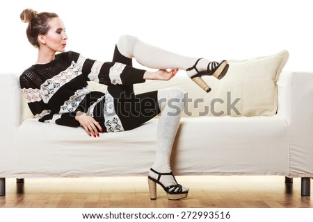 Fashion young woman in full length. Girl in fashionable striped dress high heels posing on white couch.