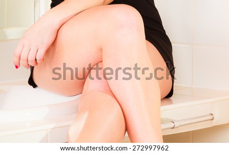 Skincare concept. Part body. Attractive woman legs black lingerie indoor.