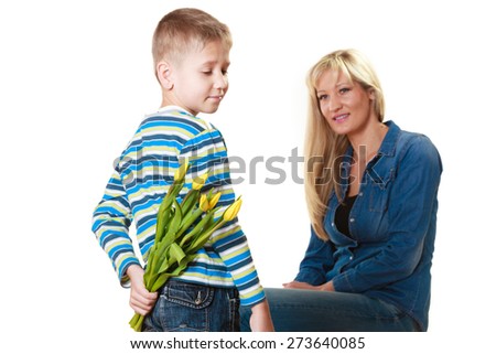 Holiday mother\'s day concept. Rear view little boy with bunch of yellow tulips behind back preparing nice surprise for his mother isolated on white