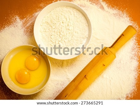 Cooking concept. Preparation for baking, bake ingredients and kitchen tools to make a cake on orange nonstick silicone mat, top view
