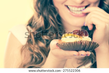 Sweetness and happiness concept. Closeup cute flirty woman eating fruit cake licks fingers