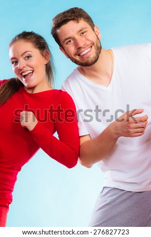 Fitness, sport, exercising concept. Portrait of sporty young happy couple man and woman having fun on blue background