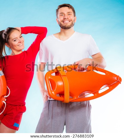 Accident prevention and water rescue. lifeguard couple on duty woman leaning on man arm, holding buoy lifesaver equipment on blue