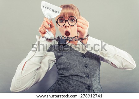 Business and stress concept. Furious businesswoman in glasses with chained hands holding contract grunge background unusual angle view