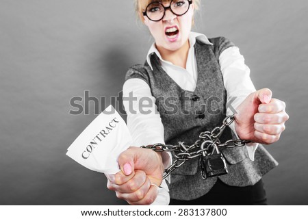 Business and stress concept. Furious businesswoman in glasses with chained hands holding contract grunge background