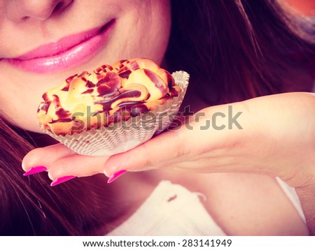 Bakery sweet food and people concept. Closeup woman holds cake cupcake in hand