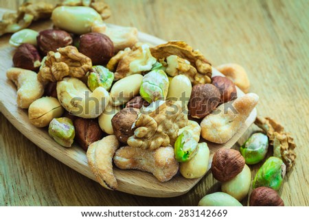 Healthy organic nutrition high fatty acids food and cuisine. Closeup varieties assortment mix of nuts on wooden spoon.