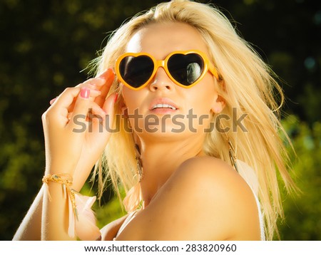 Holidays, vacation and summer fashion concept. Closeup attractive blonde girl in orange heart shaped sunglasses outdoor
