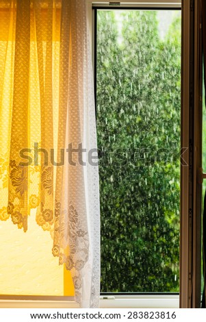 Summer rainy outside window, water drops droplets raindrops on glass windowpane. Downpour rain.