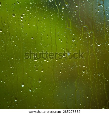 Closeup of water drops droplets raindrops on glass window as background texture. Rain. Square format.