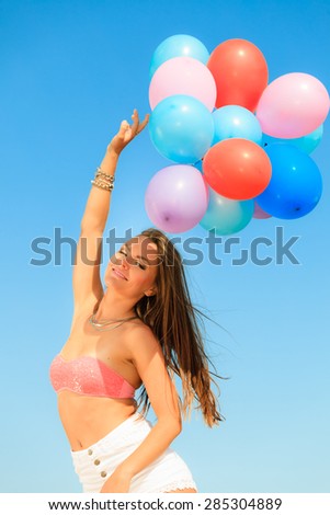 Summer holidays, celebration and lifestyle concept - attractive woman teen girl with colorful balloons outside on beach blue sky background