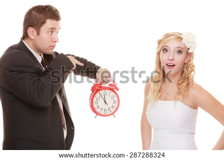 Wedding concept. Time to get married. Unhappy undecided bride and groom with red alarm clock making decision or to be late isolated on white