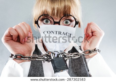 Business and stress concept. Terrified businesswoman in glasses with chained hands holding contract grunge background unusual angle view