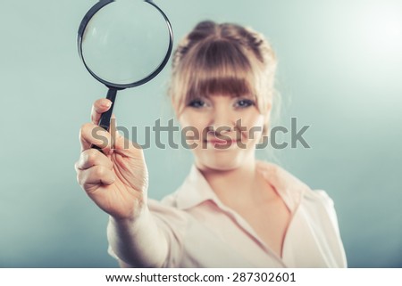 Investigation exploration education concept. Closeup woman holding magnifying glass loupe in hand filtered photo